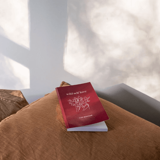 Inspirational Self-Love Book by Lisa Buscomb on a cozy couch with natural light.