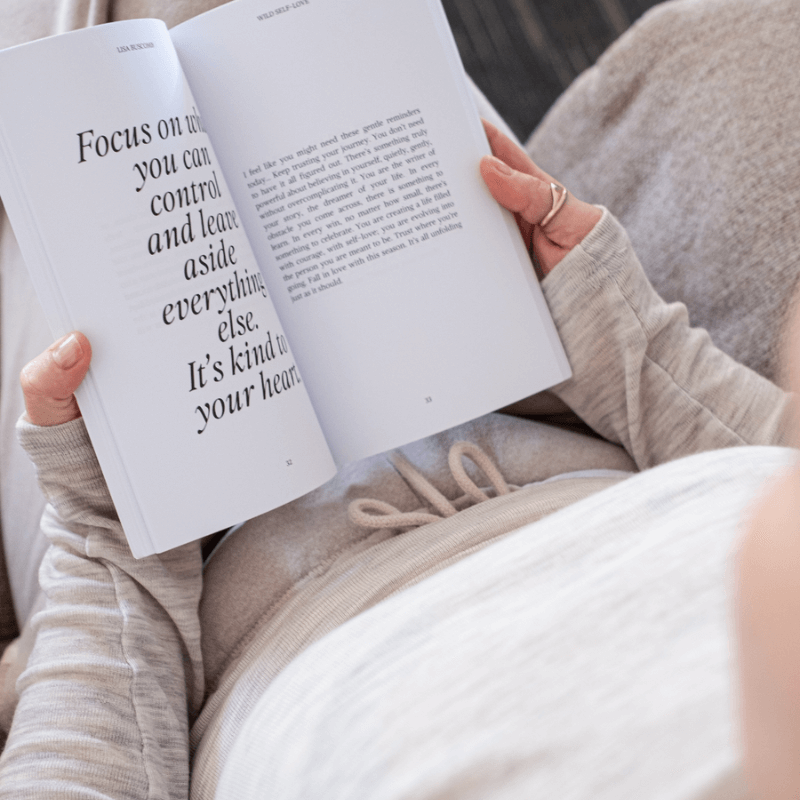 Someone reading the Inspirational Self-Love Book by Lisa Buscomb, focusing on self-love and personal growth.