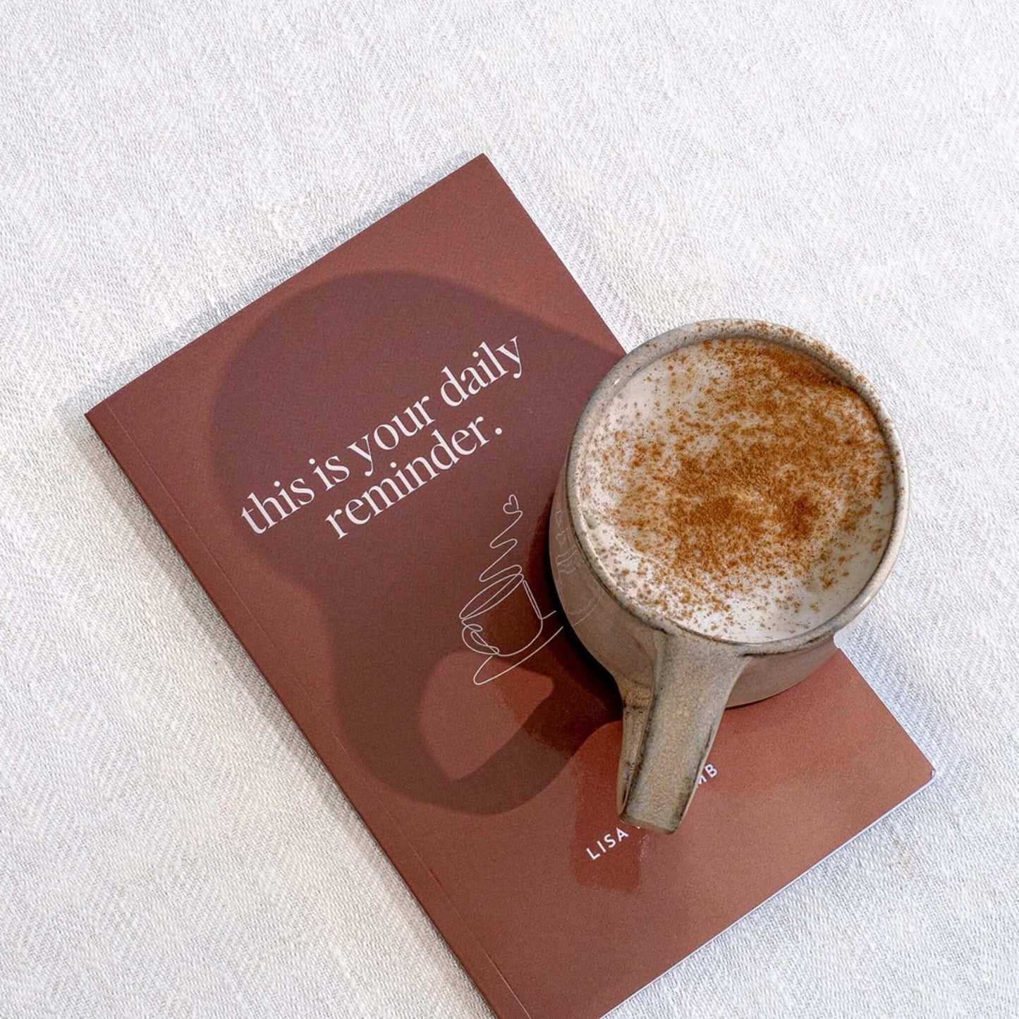 This is Your Daily Reminder Book by Lisa Buscomb with a cup of cinnamon coffee on its cover.